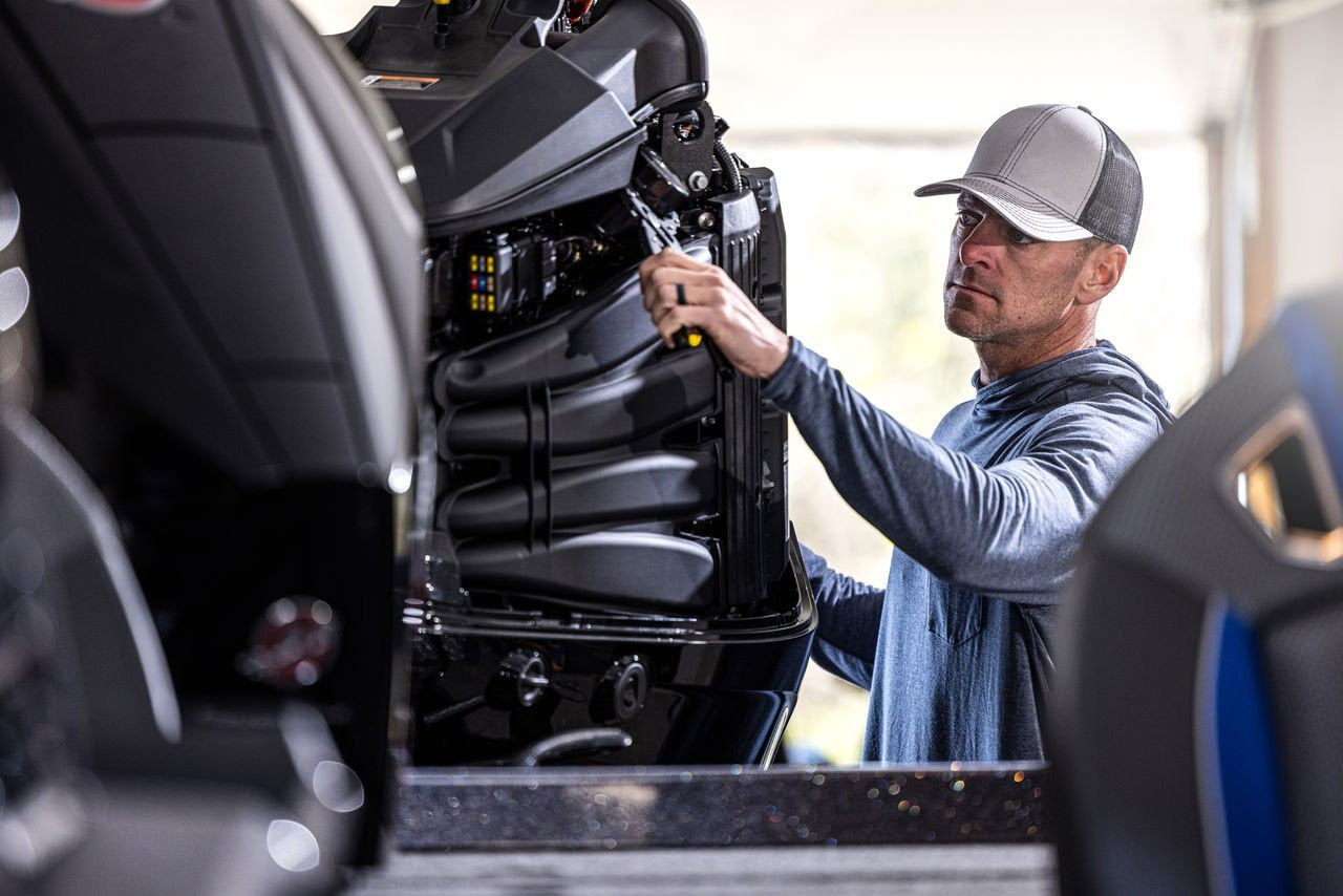 Boater winterizing an outboard motor with fuel stabilizer, oil change, and gear lube service